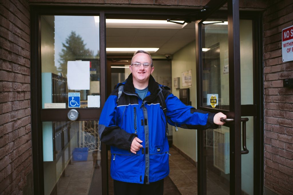 Man smiling as he leaves his apartment building